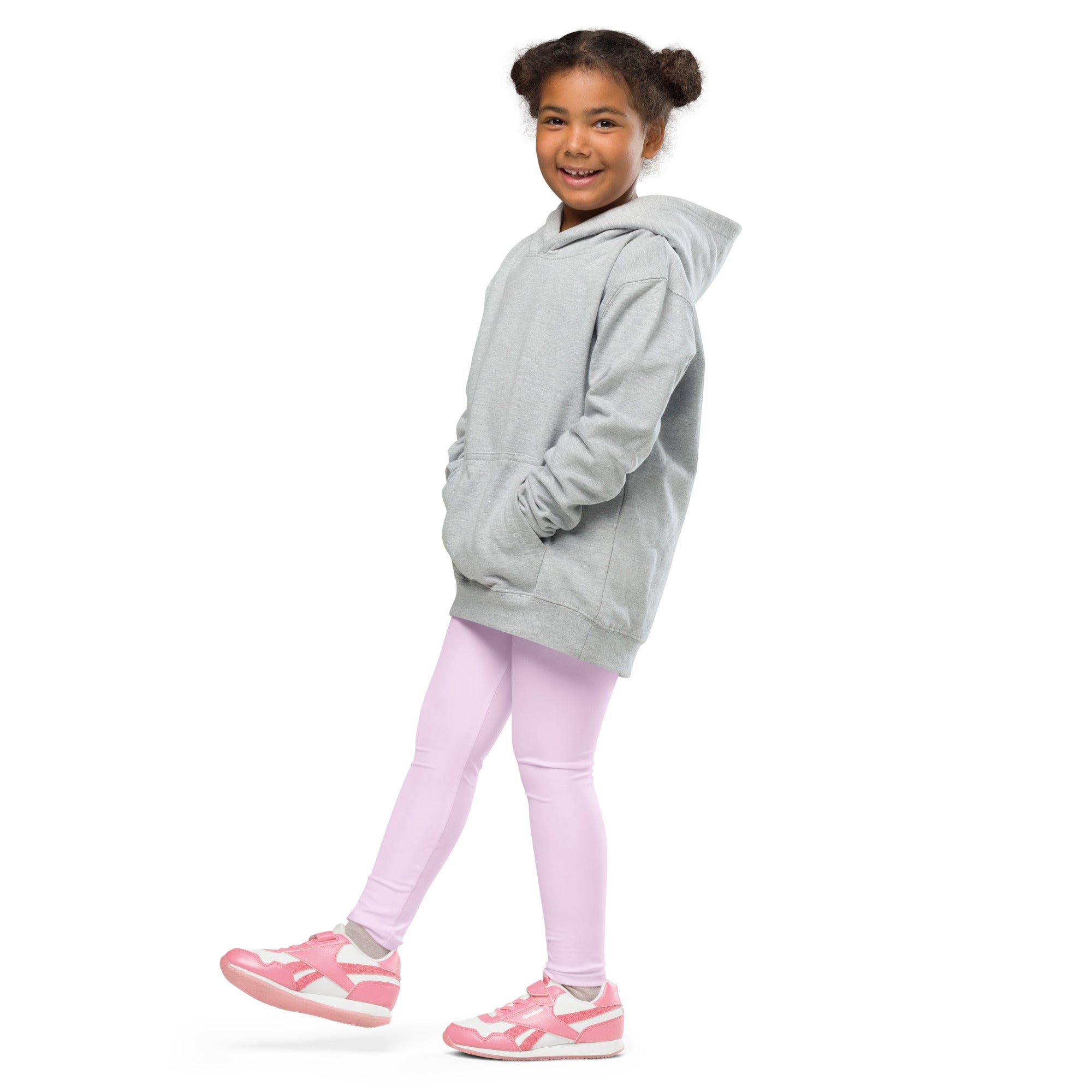 A child wearing girls buttery soft light pink leggings paired with a light gray oversized hoodie and pink sneakers