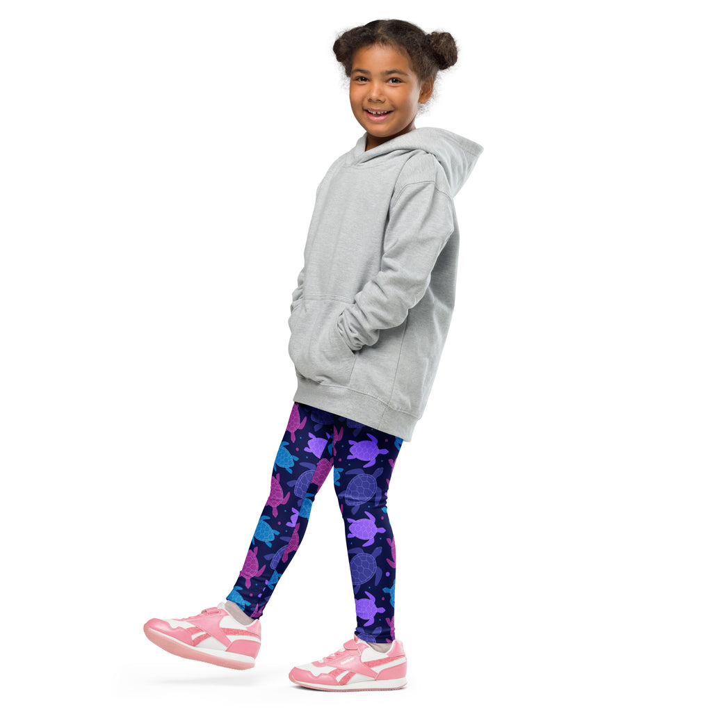 A child wearing girls purple sea turtle buttery soft leggings with a light gray hooded sweatshirt