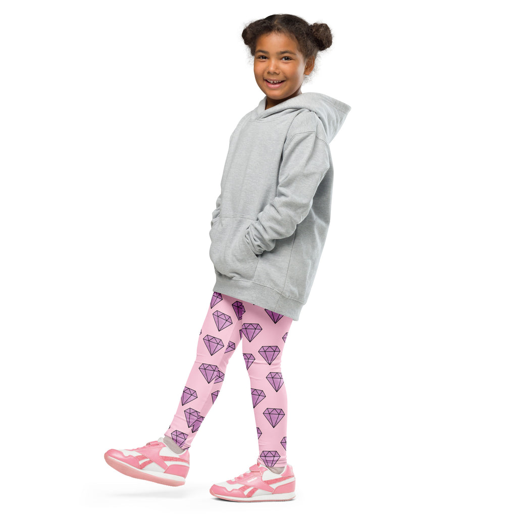 A child wearing buttery soft pink girls leggings with purple diamond patterns and a light gray hooded sweatshirt