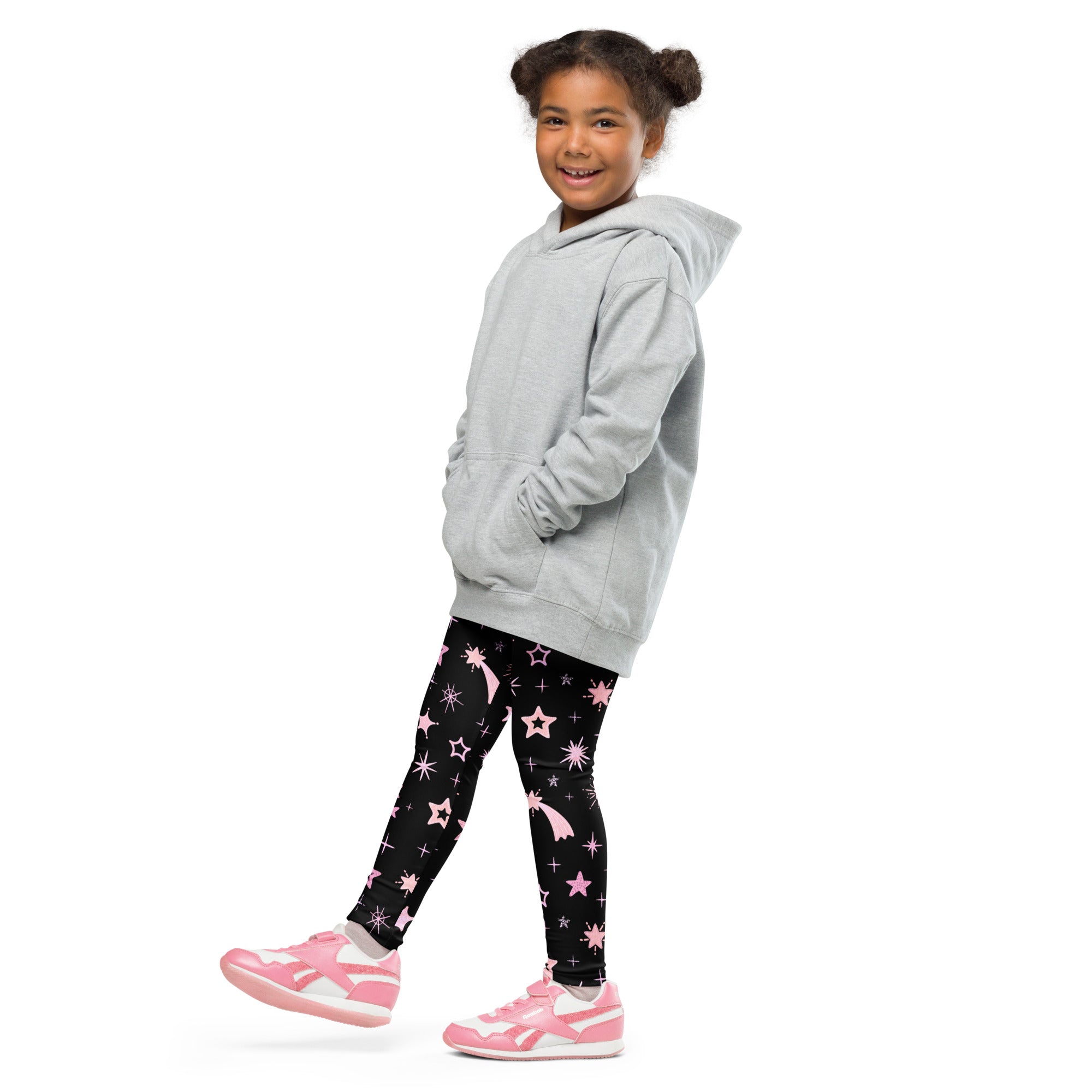 A child wearing girls pink shooting stars galaxy black leggings with pink star patterns and a light gray hooded sweatshirt