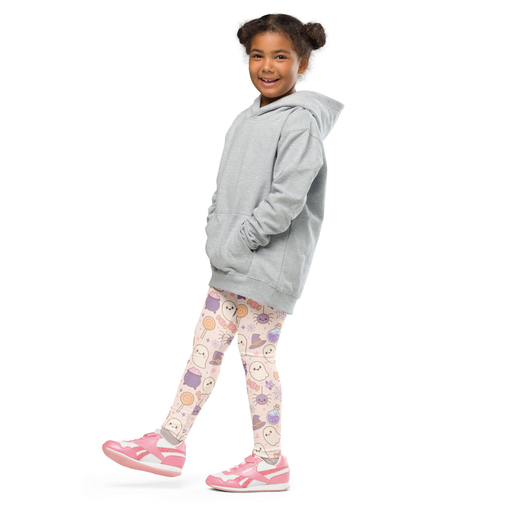 A child wearing pink cats ghosts and candy halloween buttery soft leggings and a light gray hooded sweatshirt