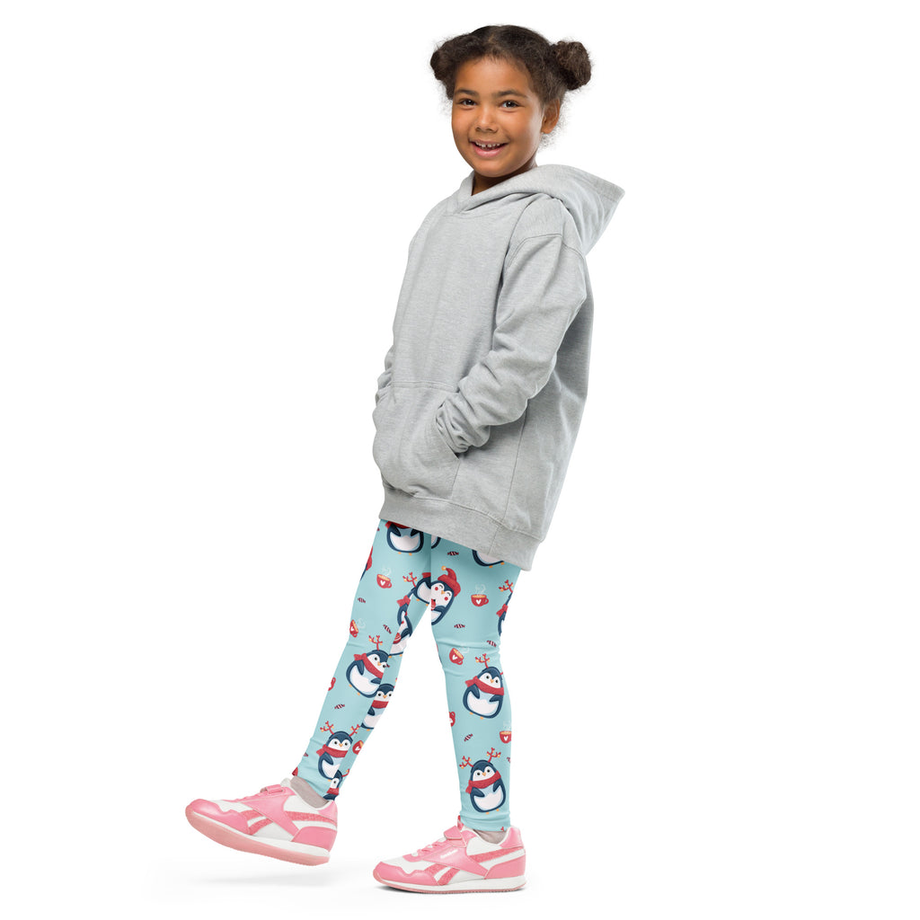 A child wearing girls cute penguin christmas buttery soft leggings in teal with penguin patterns and a gray hooded sweatshirt