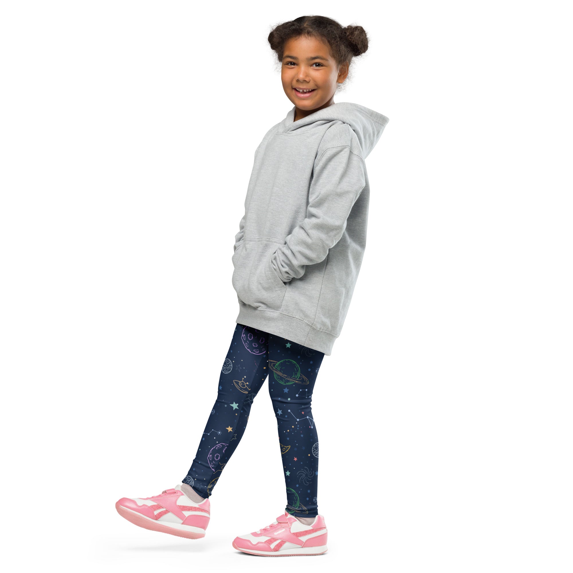 A child wearing kids colorful galaxy space buttery soft leggings in dark blue with celestial designs and a gray hooded sweatshirt