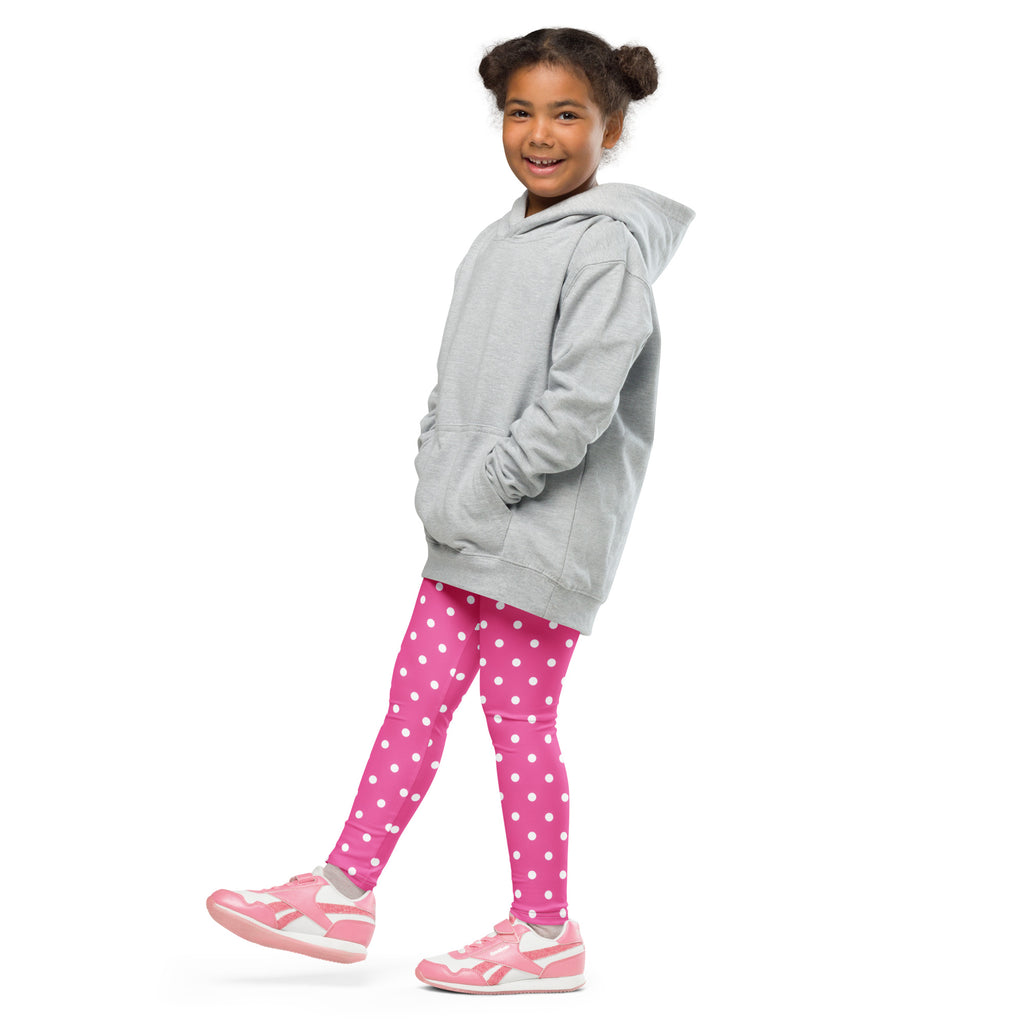 A young girl wearing girls pink polka dot buttery soft leggings and a gray hooded sweatshirt