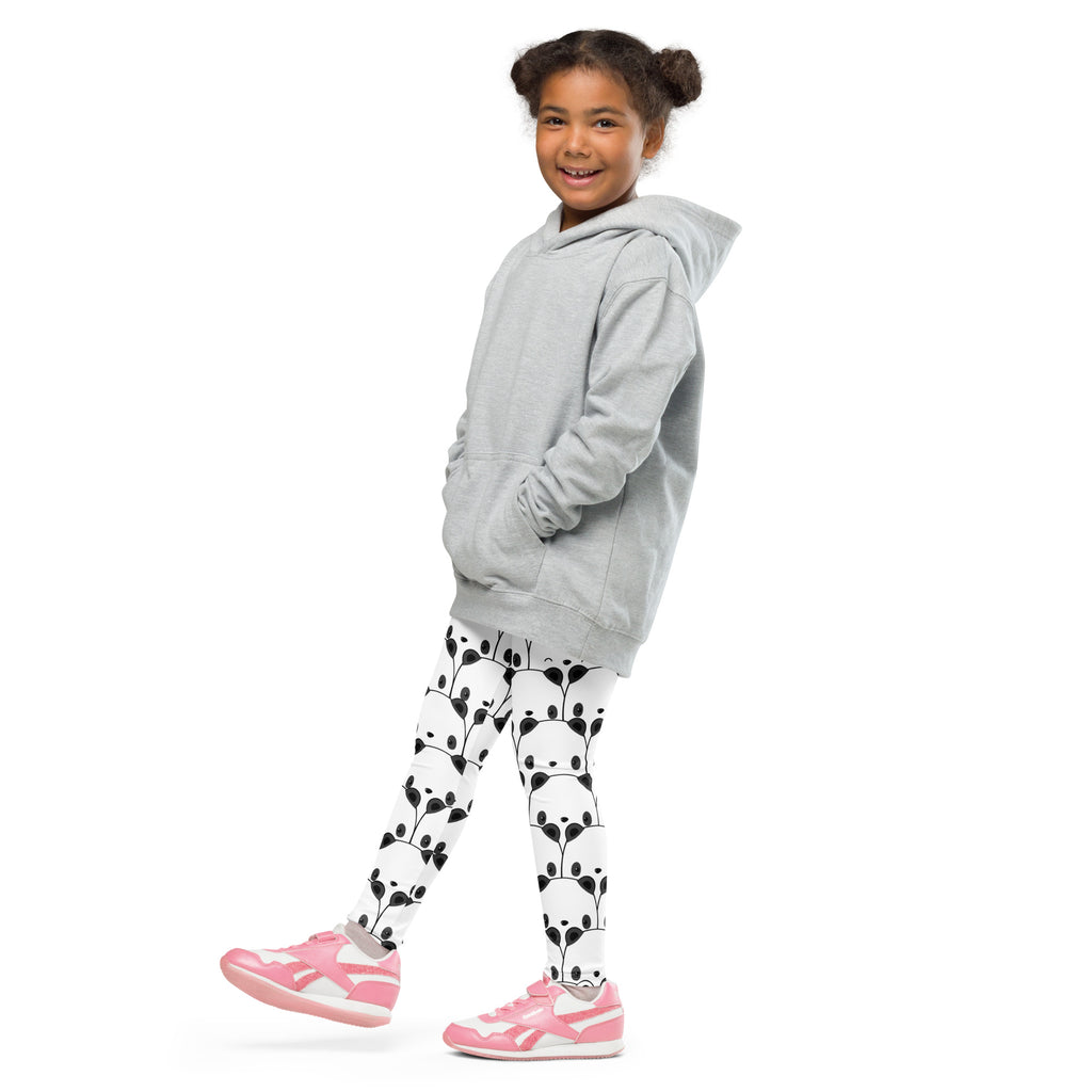 A child wearing black and white panda buttery soft leggings paired with a light gray hooded sweatshirt and pink sneakers