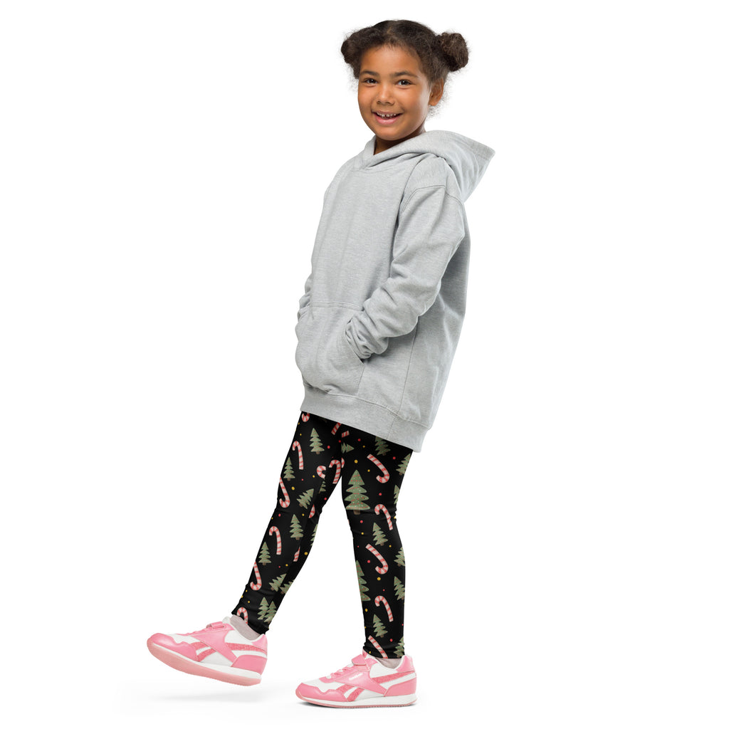 A child wearing kids christmas candy canes and trees buttery soft black leggings with pink candy cane and green tree patterns