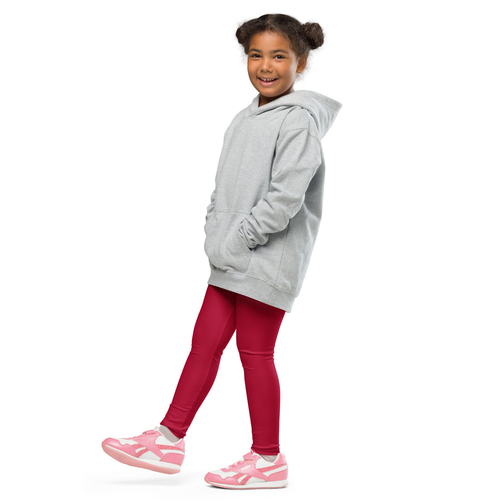 A young girl wearing kids dark red buttery soft leggings paired with a light gray hooded sweatshirt and pink sneakers