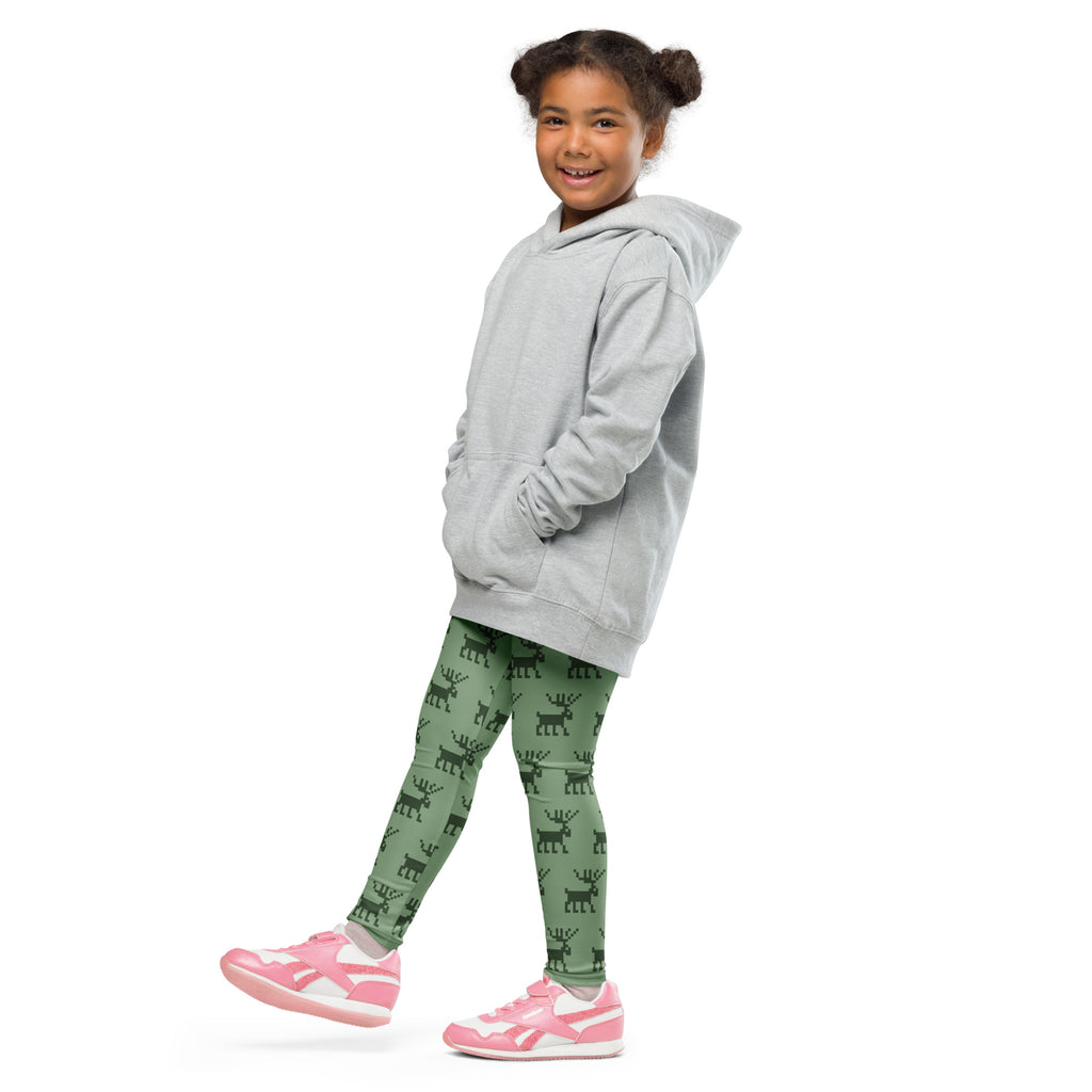 A child wearing kids green pixel reindeer Christmas buttery soft leggings with a light gray hooded sweatshirt and pink shoes