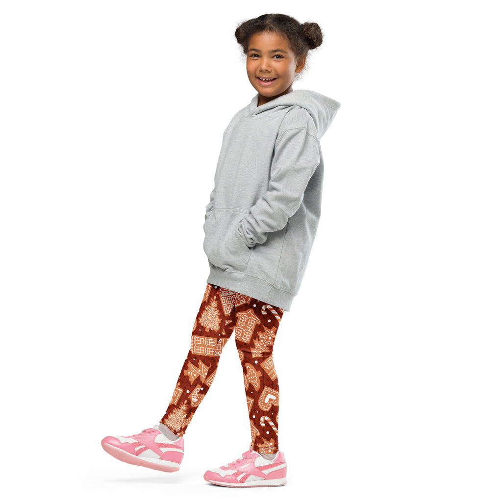 A child wearing buttery soft festive brown kids red gingerbread cookie christmas leggings and a light gray hoodie