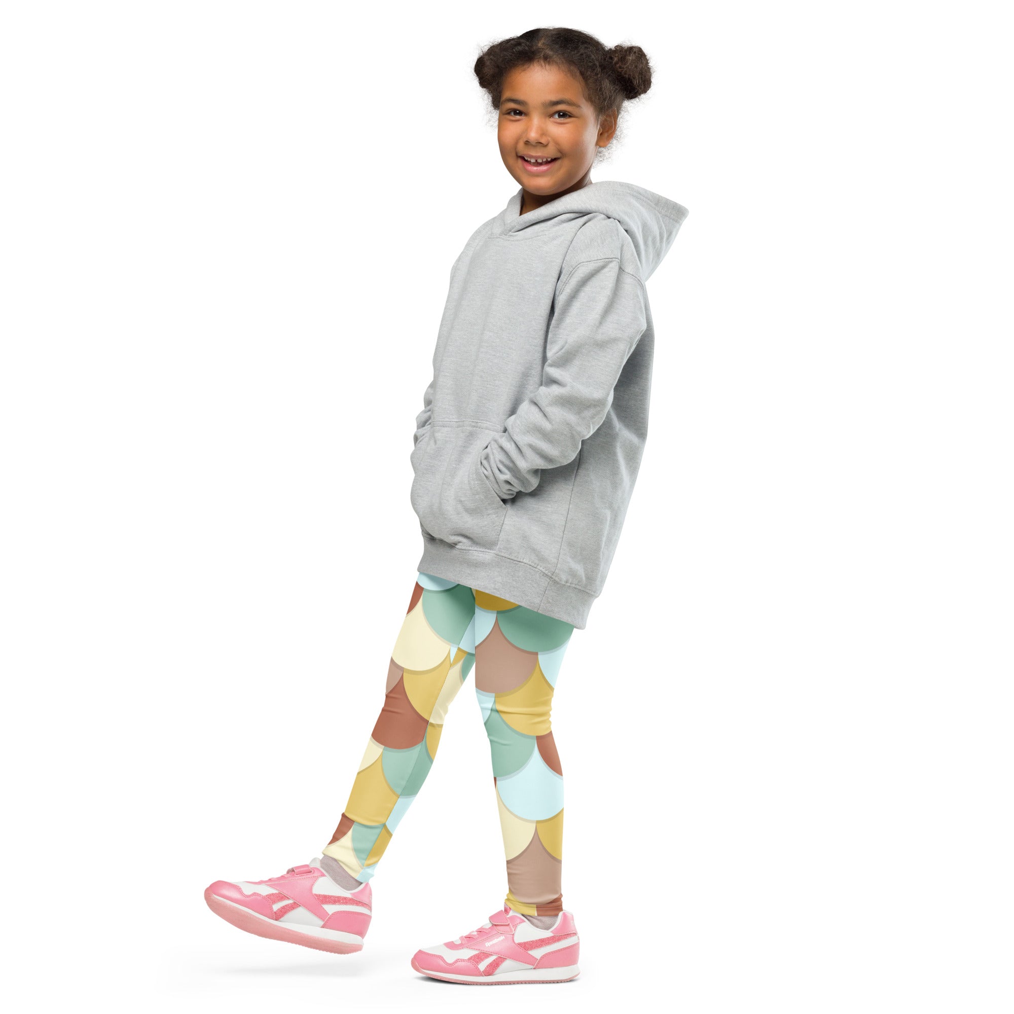 A young girl wearing girls green and brown mermaid buttery soft leggings with a soft gray hooded sweatshirt