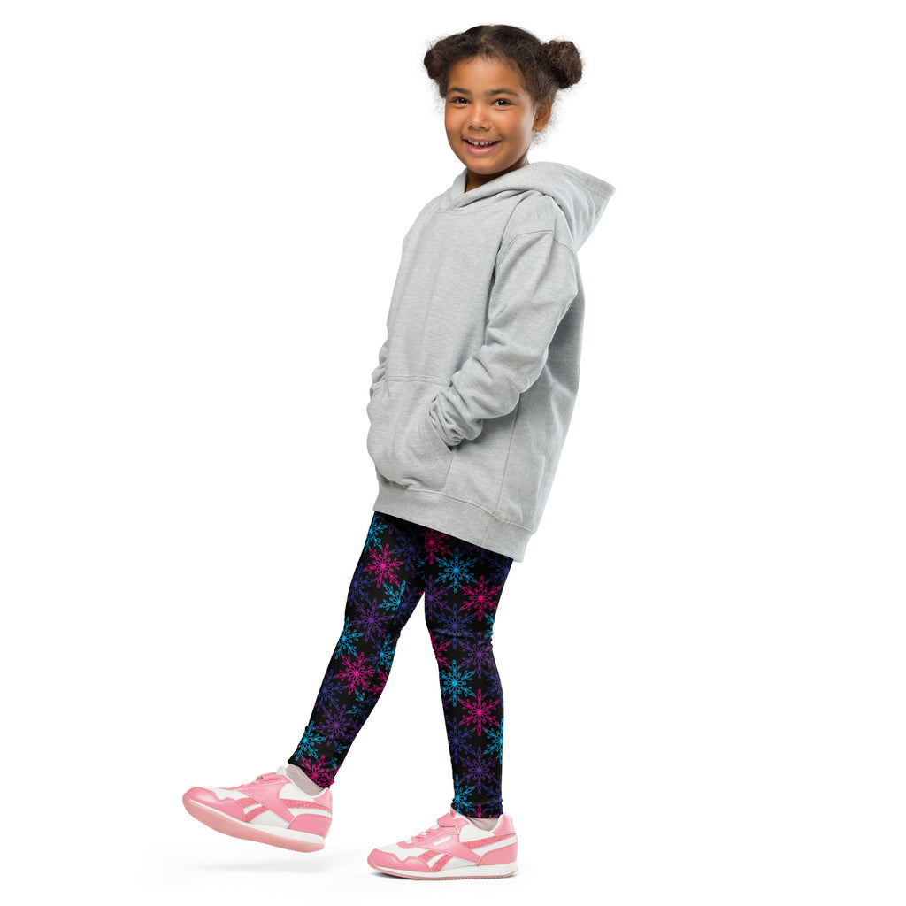 A child wearing girls neon snowflake buttery soft leggings with vibrant multicolored snowflake patterns and a gray hoodie