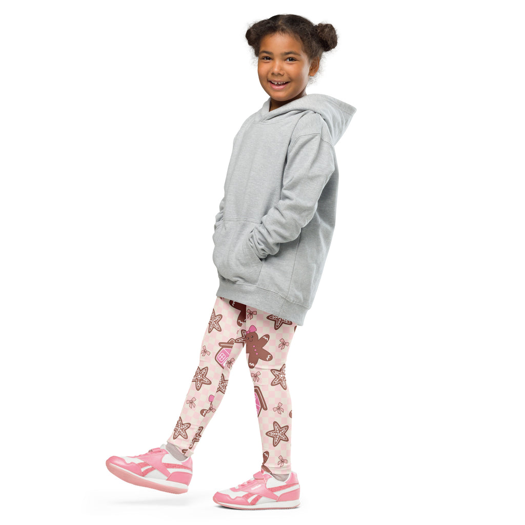 A young girl wearing girls pink gingerbread christmas buttery soft leggings with starfish and candy cane patterns