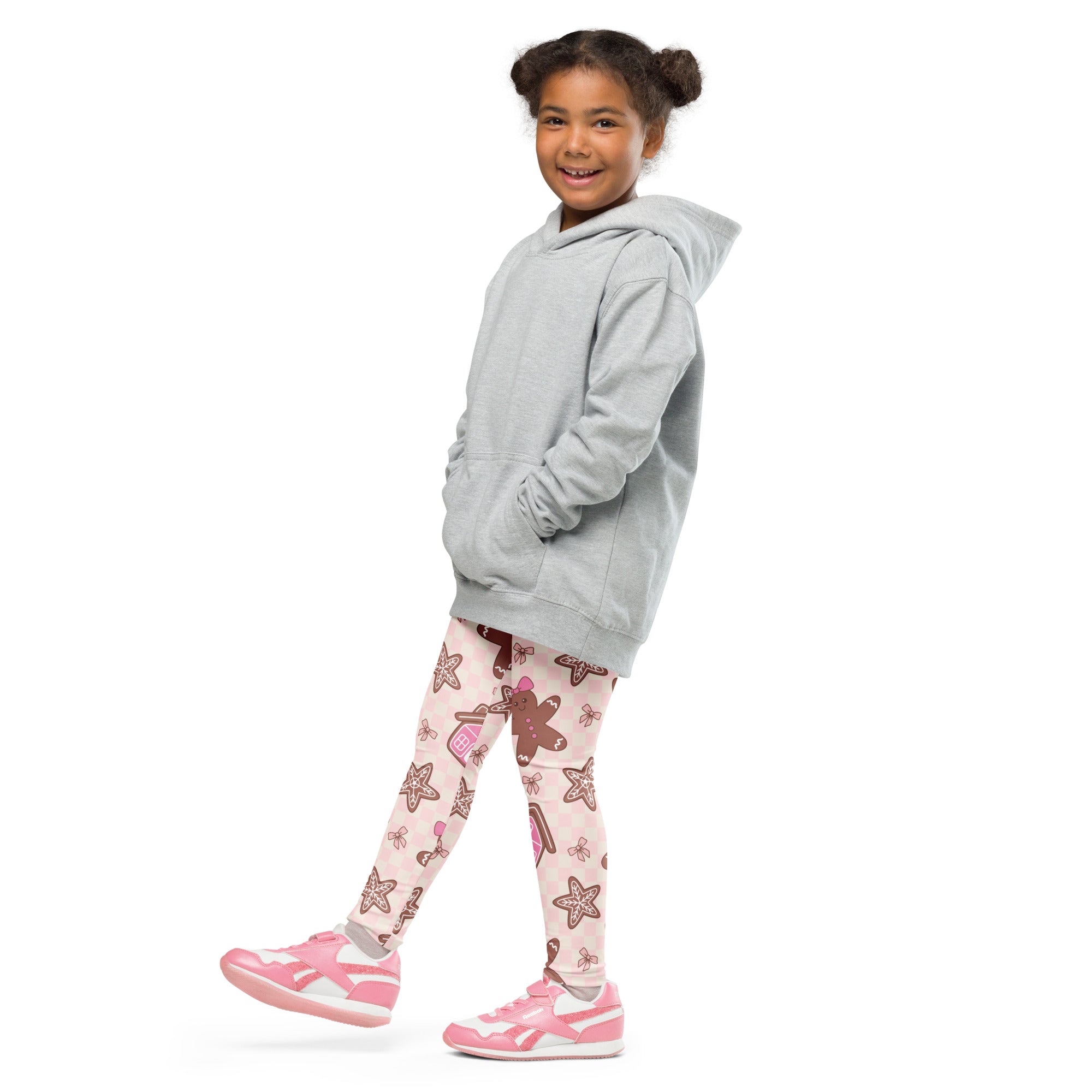 A young girl wearing girls pink gingerbread christmas buttery soft leggings with starfish and candy cane patterns