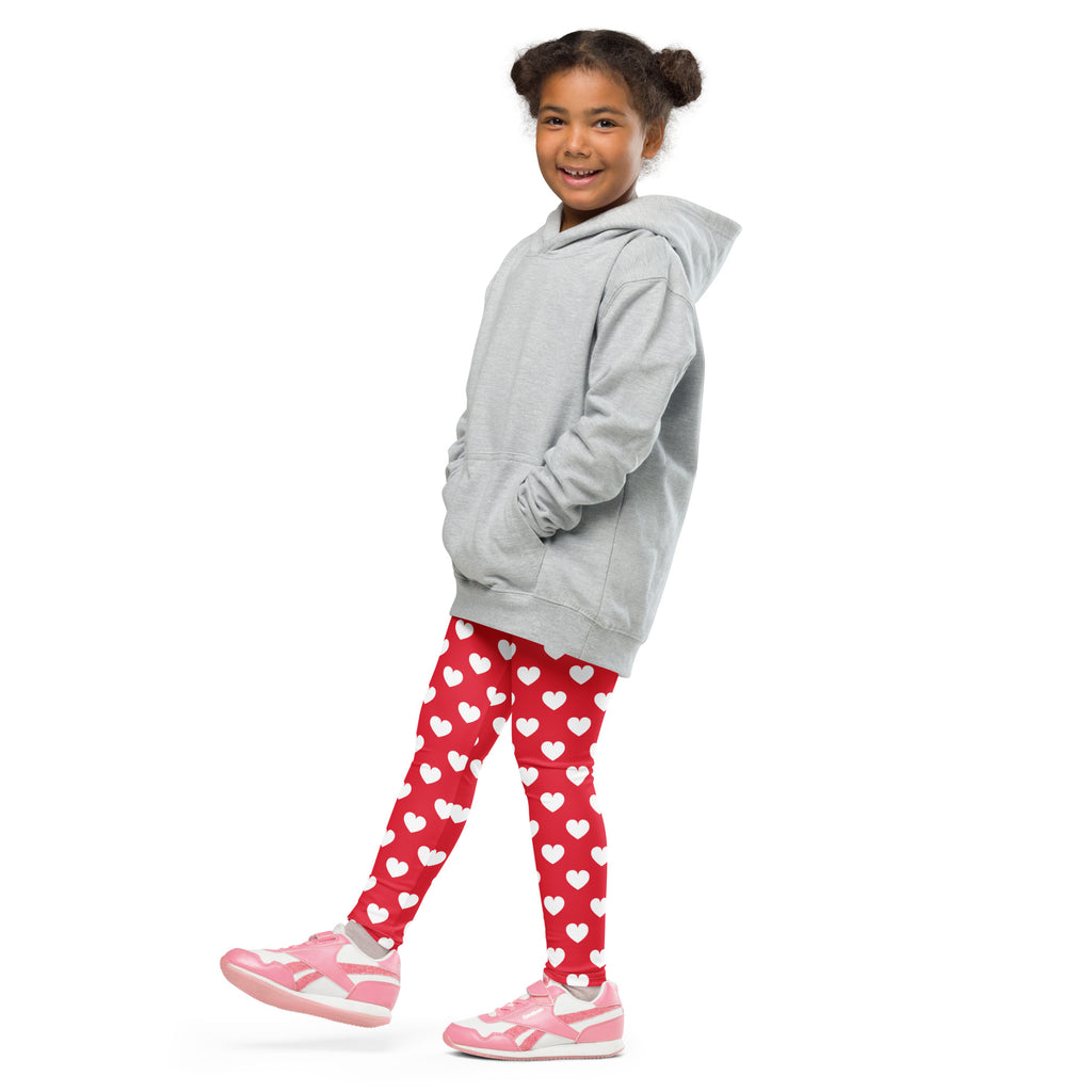 A child wearing girls red heart buttery soft leggings in red with a gray hooded sweatshirt and pink sneakers