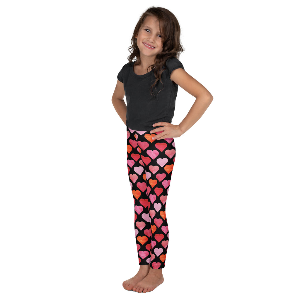Girls black buttery soft leggings with vibrant pink and orange heart pattern on front side