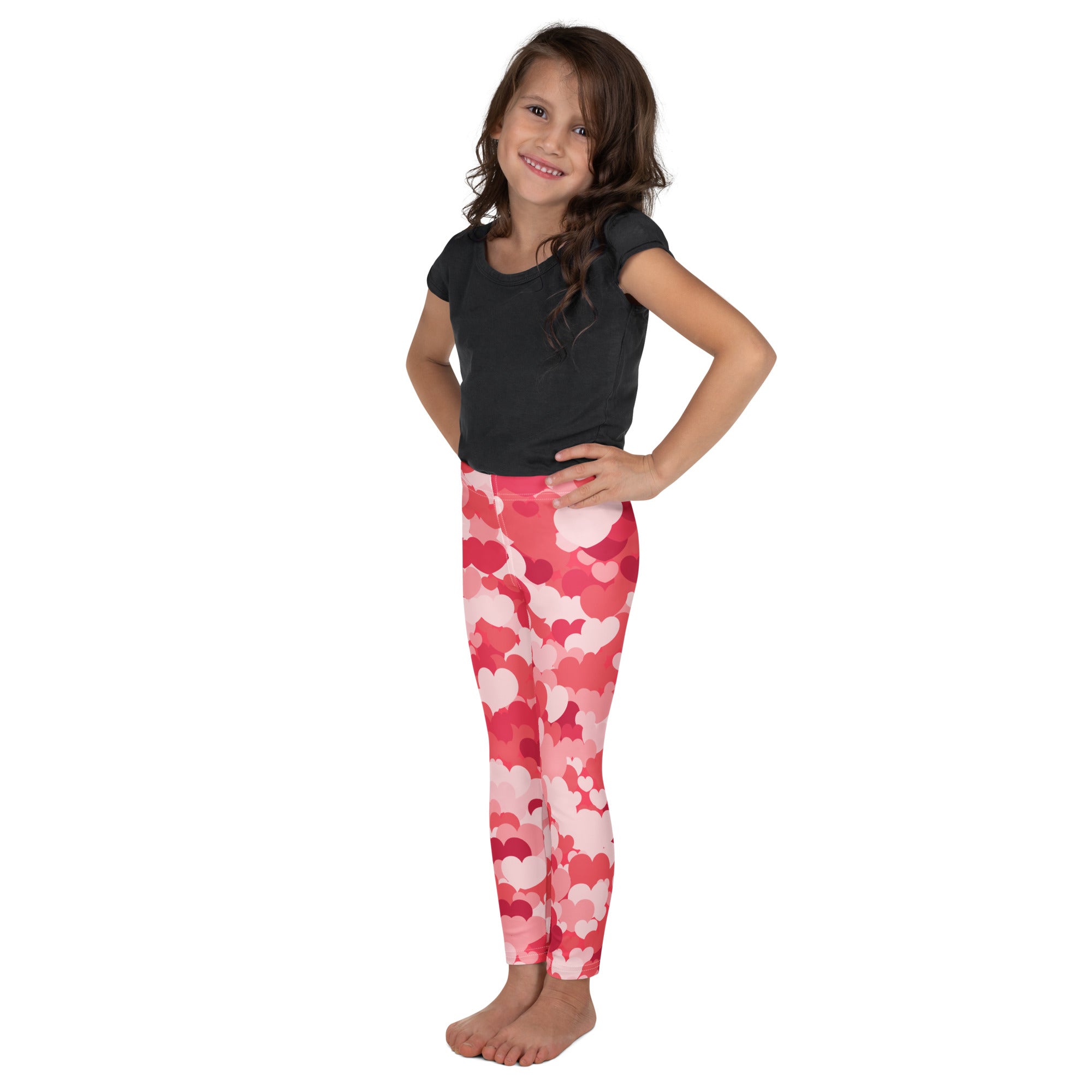 Girls pink heart cloud leggings with pink and red heart patterns made of buttery soft fabric worn by a young girl