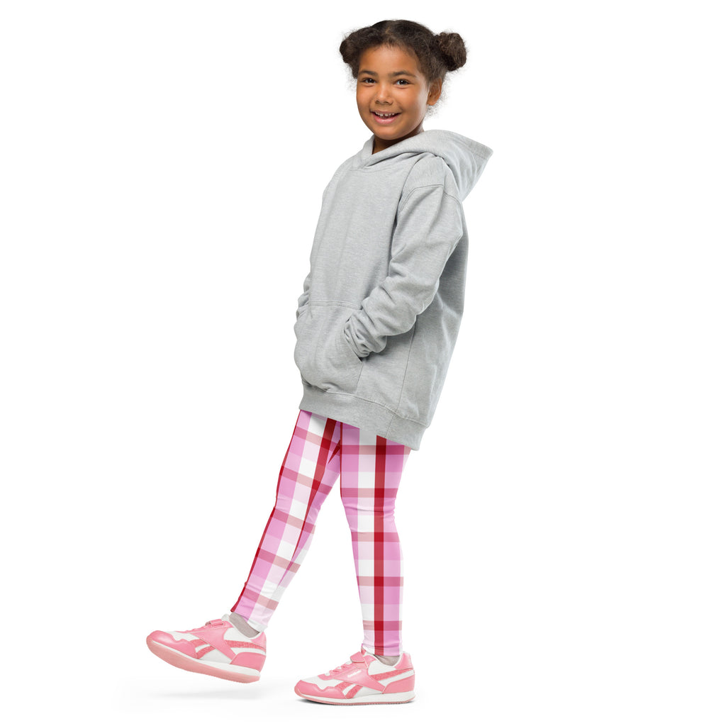 A young girl wearing girls pink and red plaid buttery soft leggings with gray hoodie and matching pink sneakers