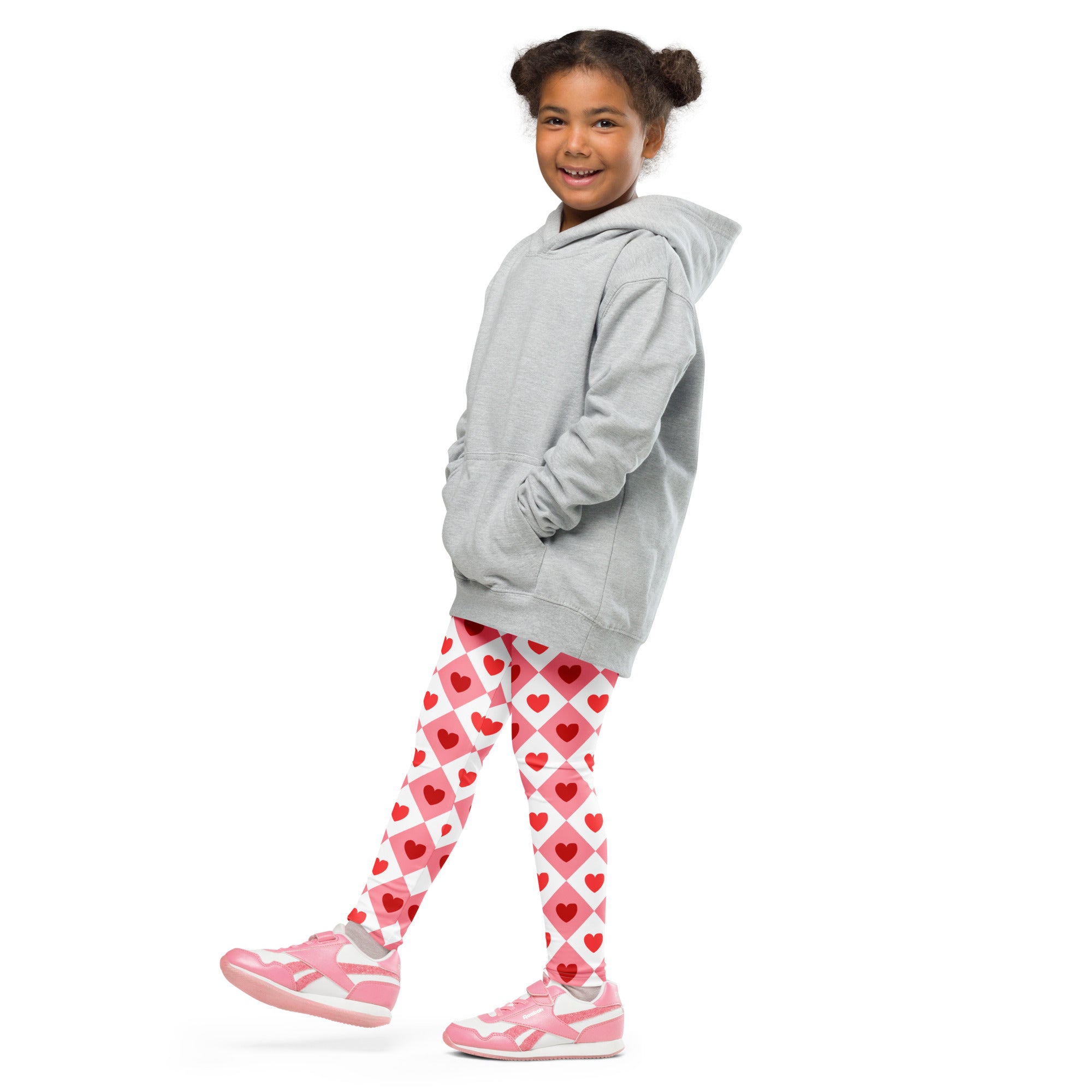 A child wearing girls pink argyle heart leggings buttery soft pink leggings with matching pink sneakers and gray hoodie