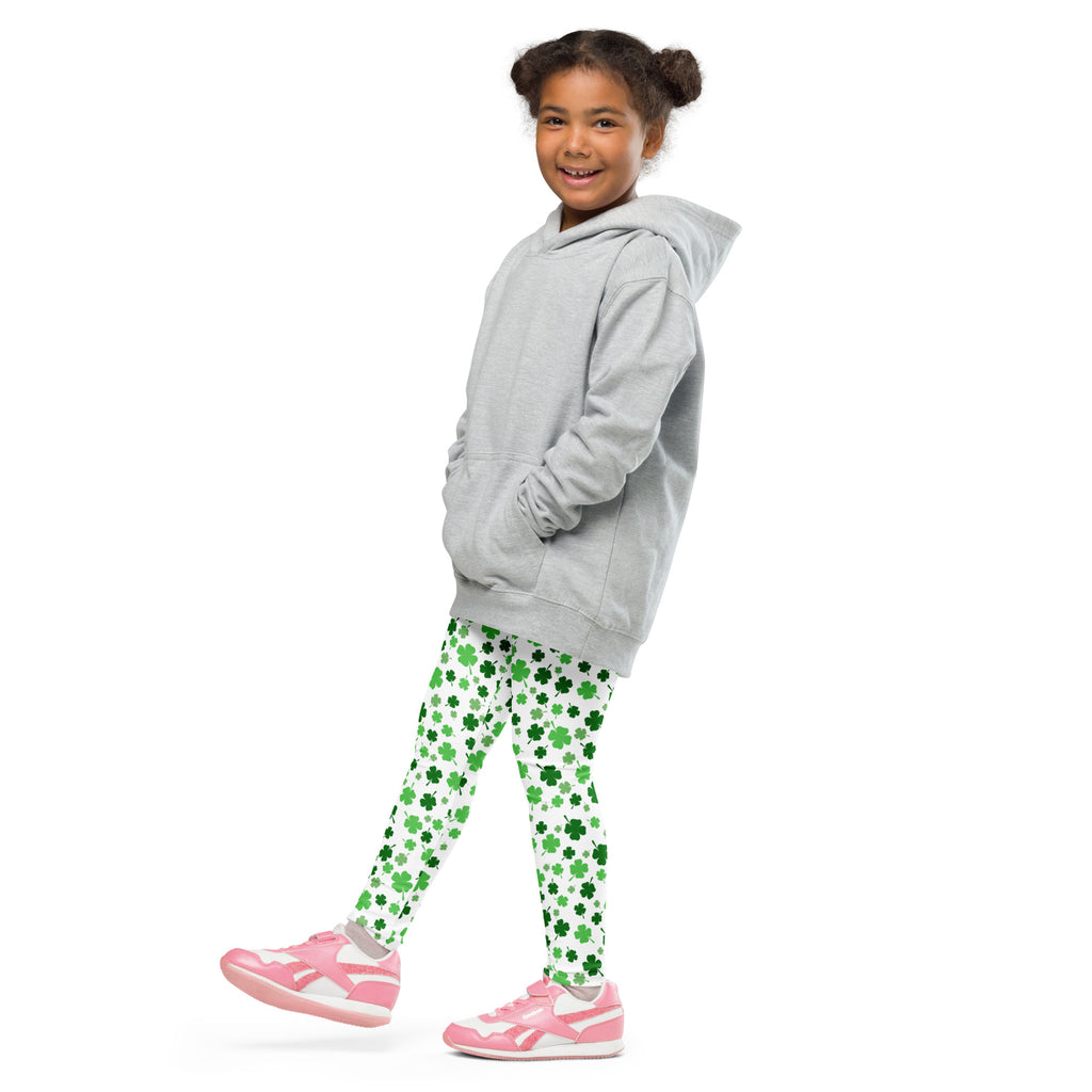 A child wearing girls shamrock print buttery soft green leggings paired with pink sneakers and a gray hooded sweatshirt