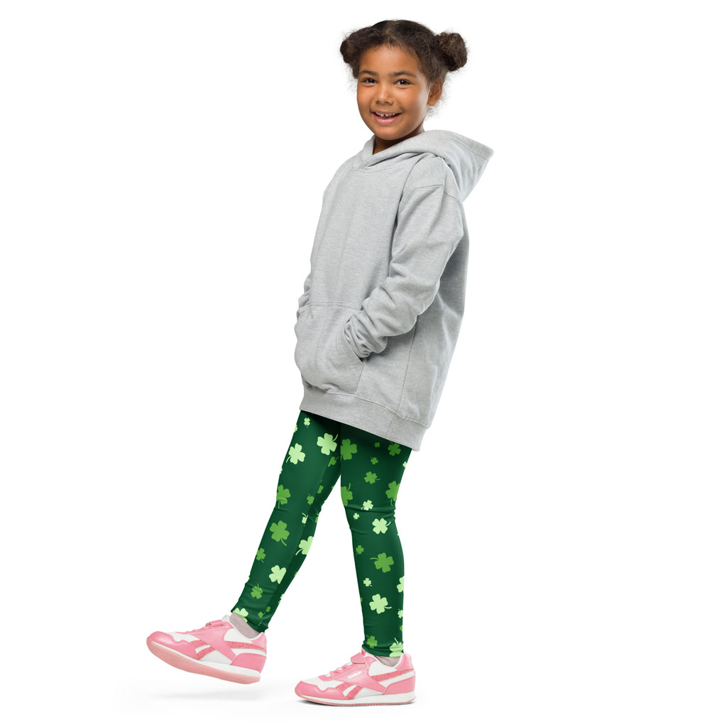 A young girl wearing green girls lucky clover St Patricks Day buttery soft leggings with shamrock patterns