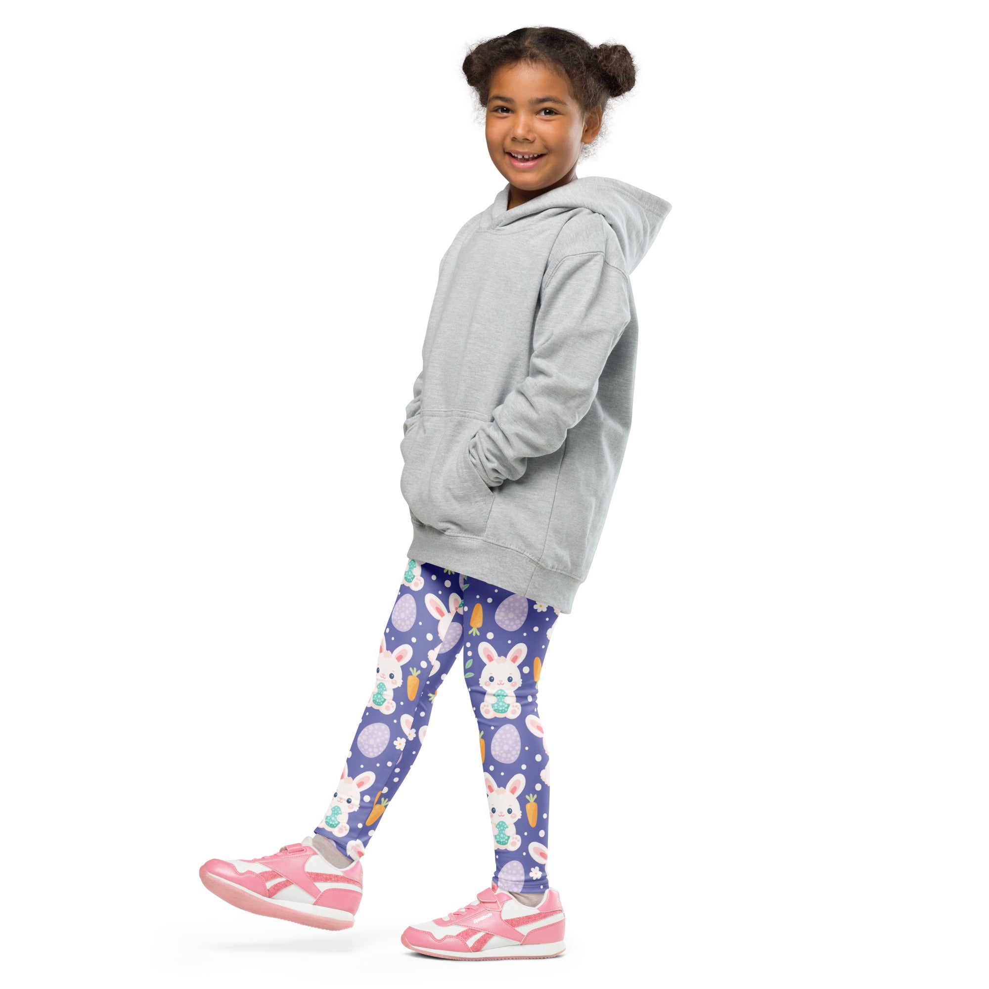 A child wearing girls purple Easter bunny buttery soft leggings with white bunny and egg patterns and pink sneakers