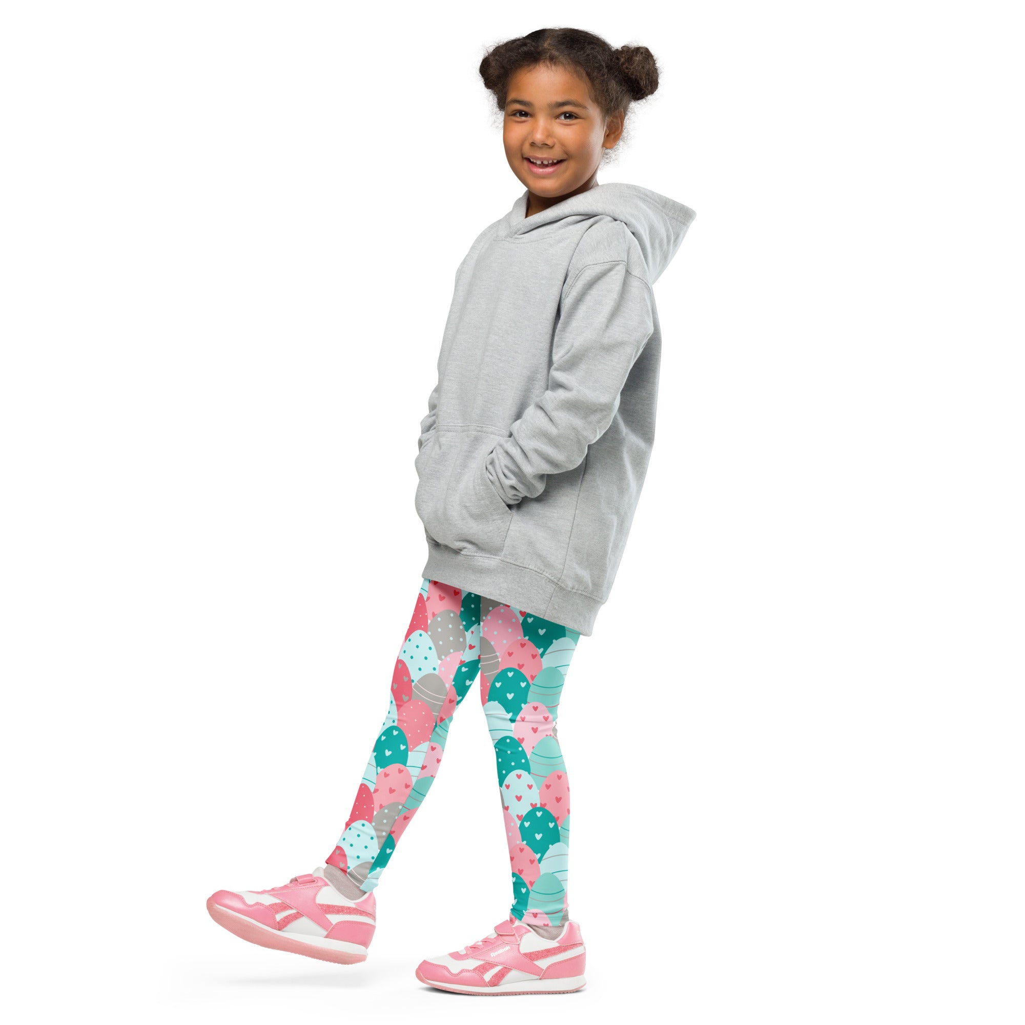 A child wearing girls pink and teal Easter eggs buttery soft leggings with ice cream print and pink sneakers