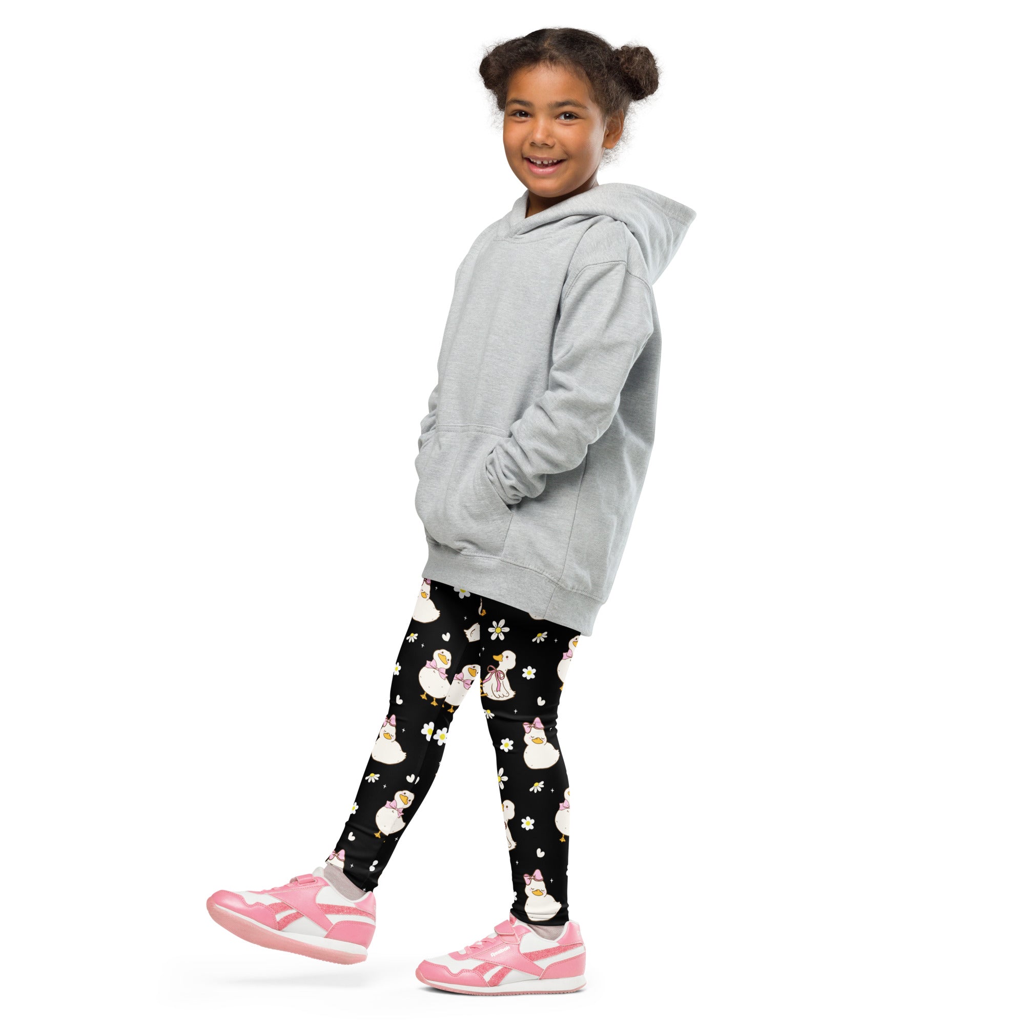 A child wearing black girls Easter duck buttery soft leggings with white penguin prints and a light gray hooded sweatshirt