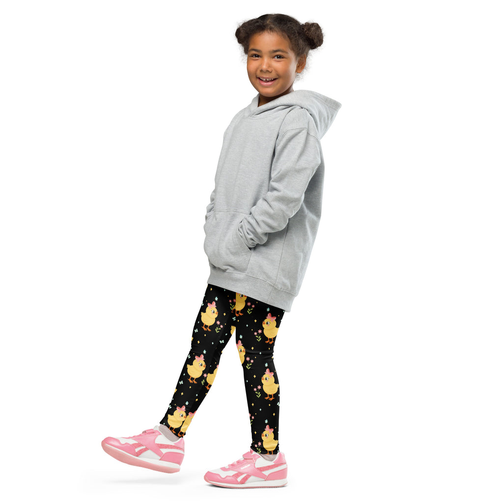 A child wearing girls black cute chick Easter buttery soft leggings with yellow chick patterns and a light gray hoodie