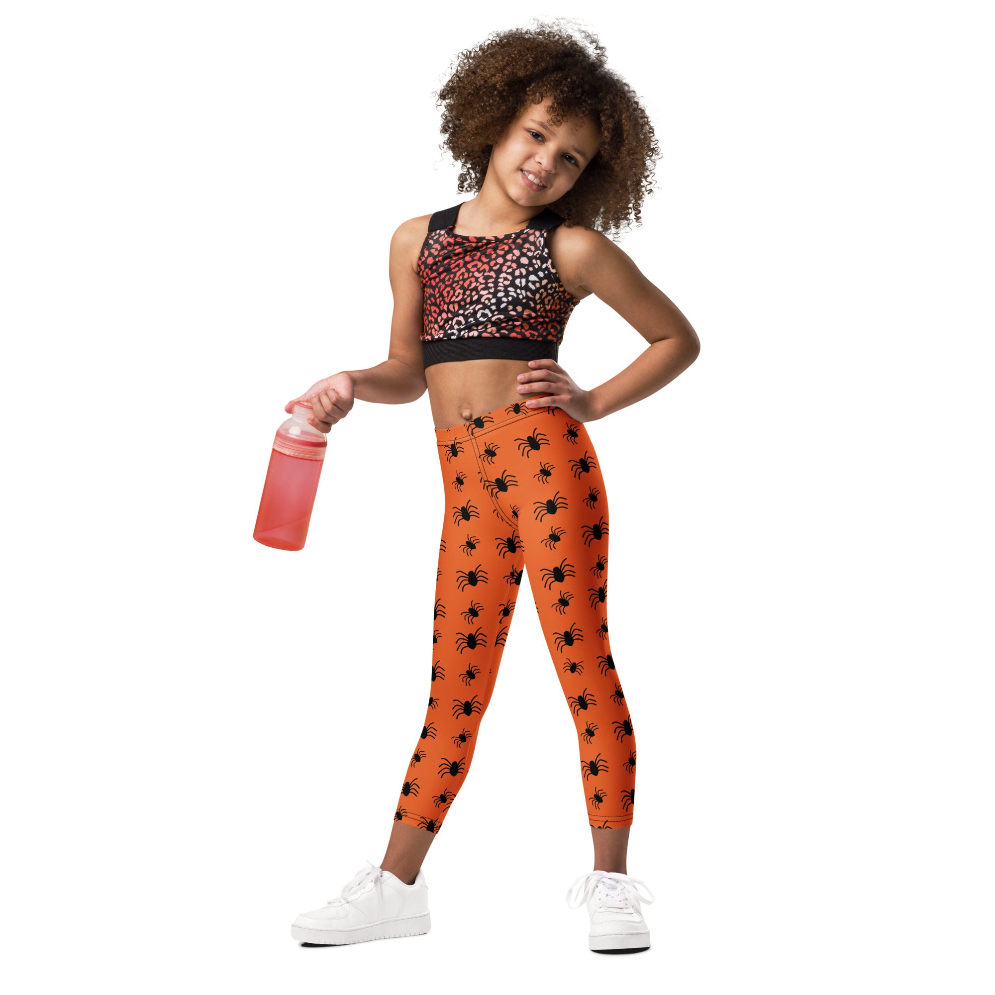 Kids orange spider halloween buttery soft leggings featuring black spider patterns on vibrant orange fabric
