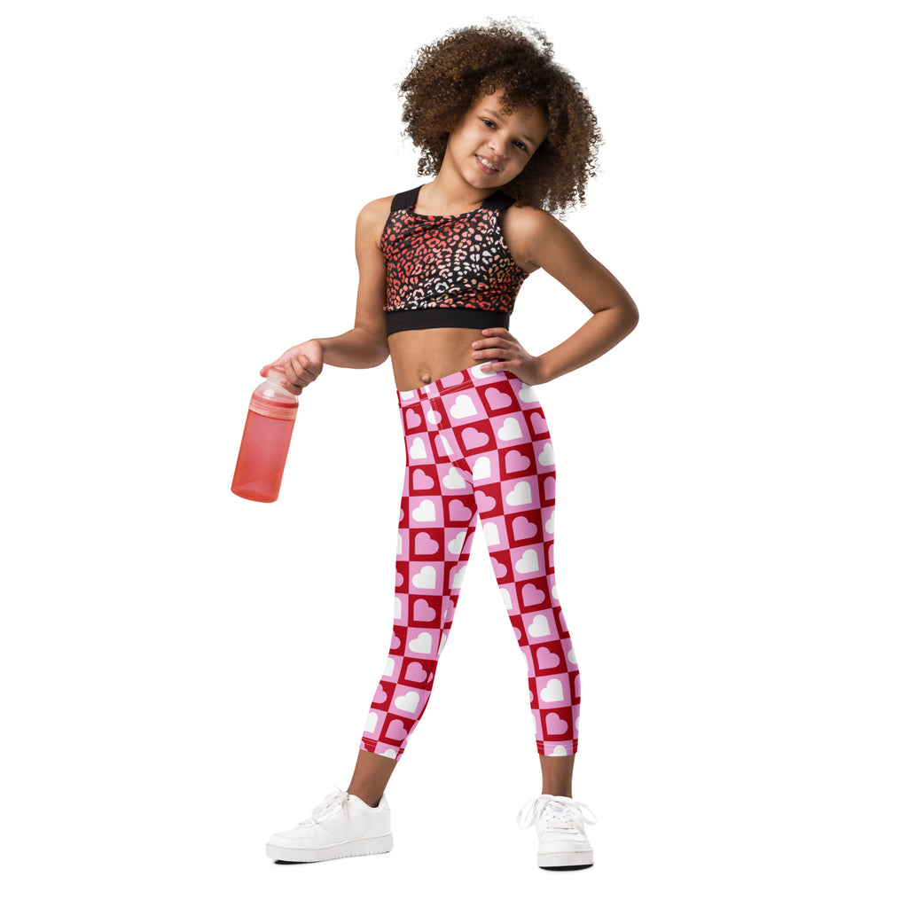 Girls pink checkered heart buttery soft leggings feature pink and white heart pattern with a red grid design