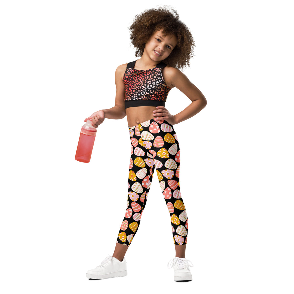 Girls bold easter egg buttery soft leggings in black with vibrant pink yellow and orange stylized egg patterns