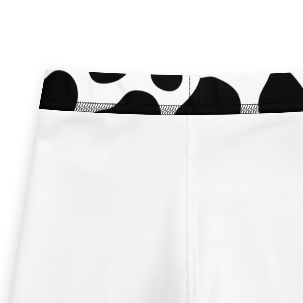 Kids cow print buttery soft leggings in white with a black cow print waistband for comfortable wear