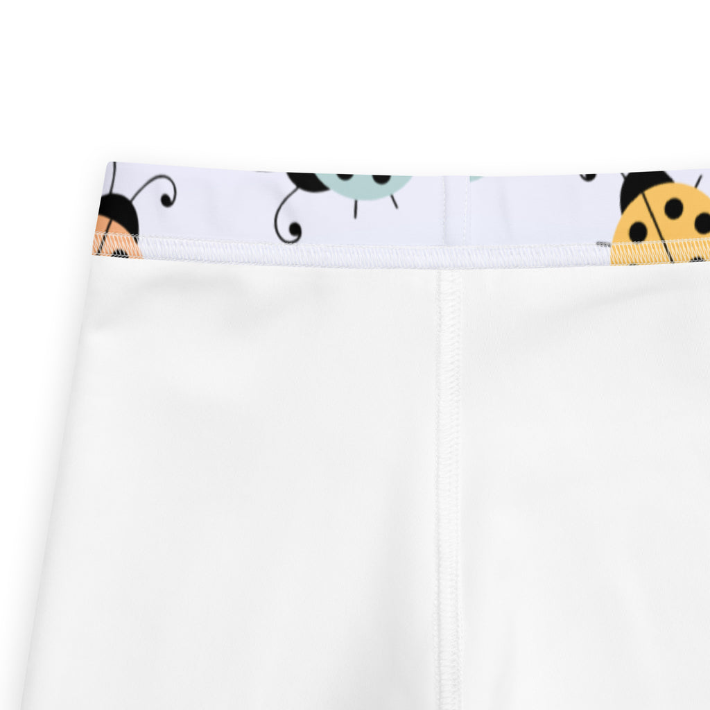 White girls buttery soft leggings with colorful playful ladybug pattern along the waistband