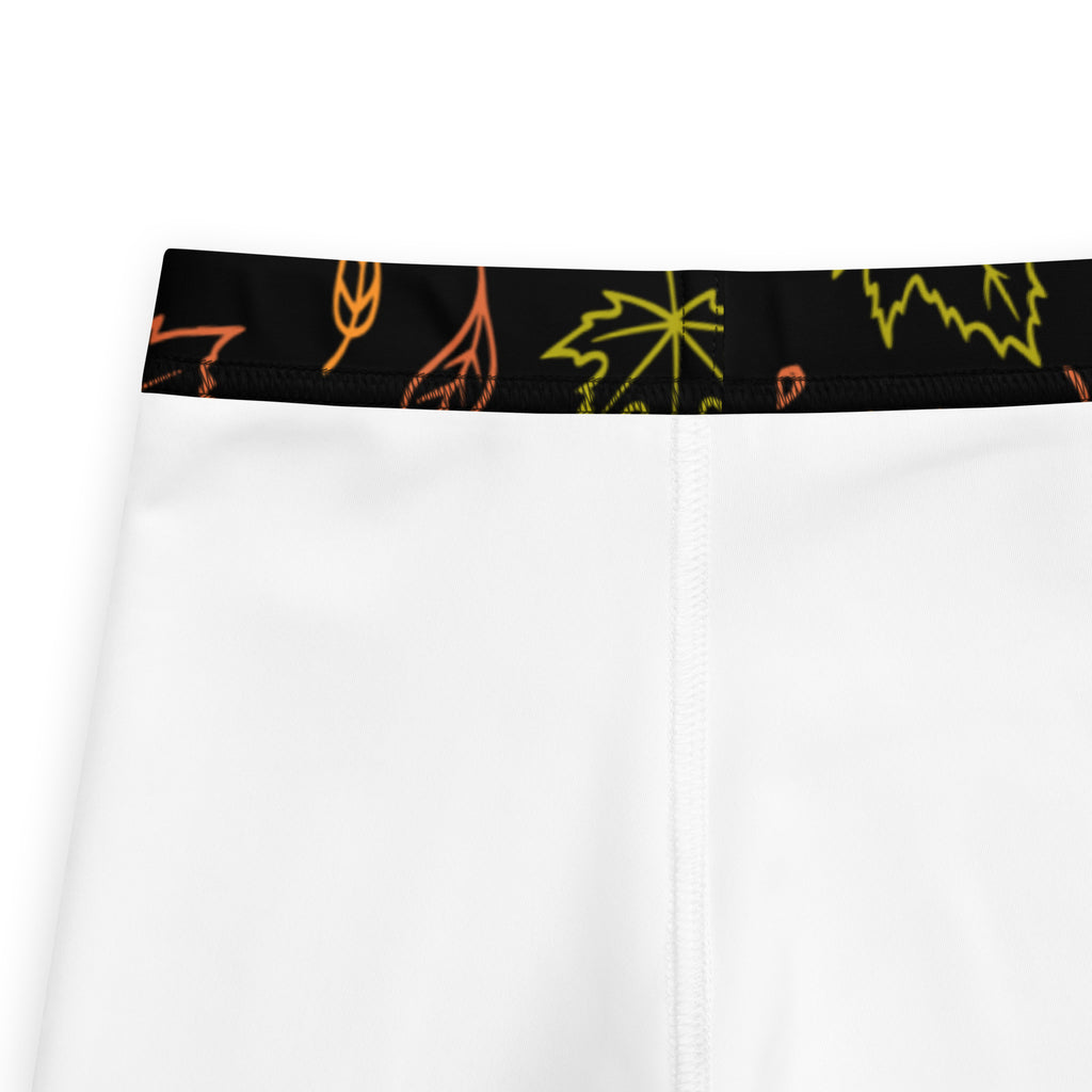 Kids fall leaf buttery soft leggings in white with black waistband and neon orange and yellow leaf patterns