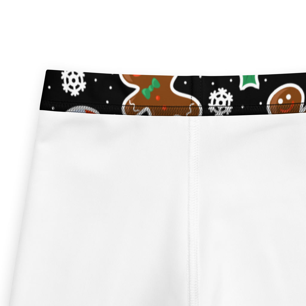 White kids leggings with a black festive waistband featuring gingerbread men and snowflakes buttery soft fabric