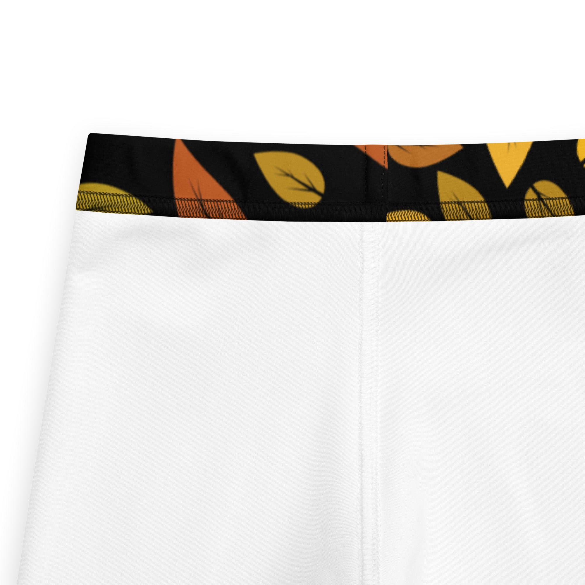 White kids autumn leaf buttery soft leggings with black waistband and yellow orange leaf pattern on front side