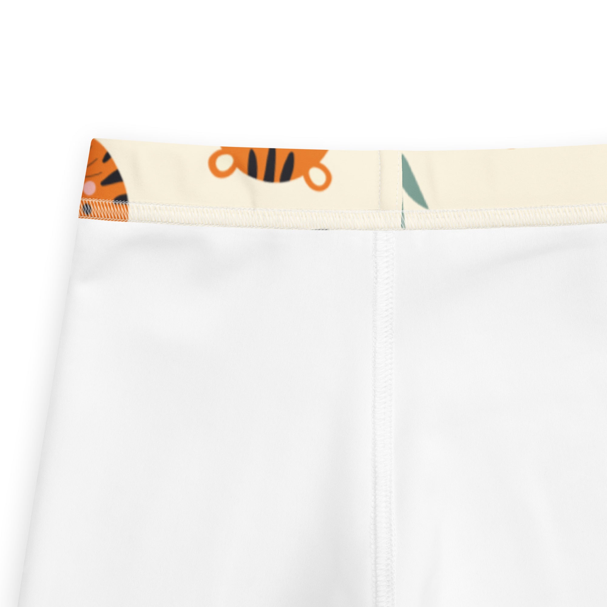 White kids buttery soft leggings with a playful tiger and leaf print on the waistband