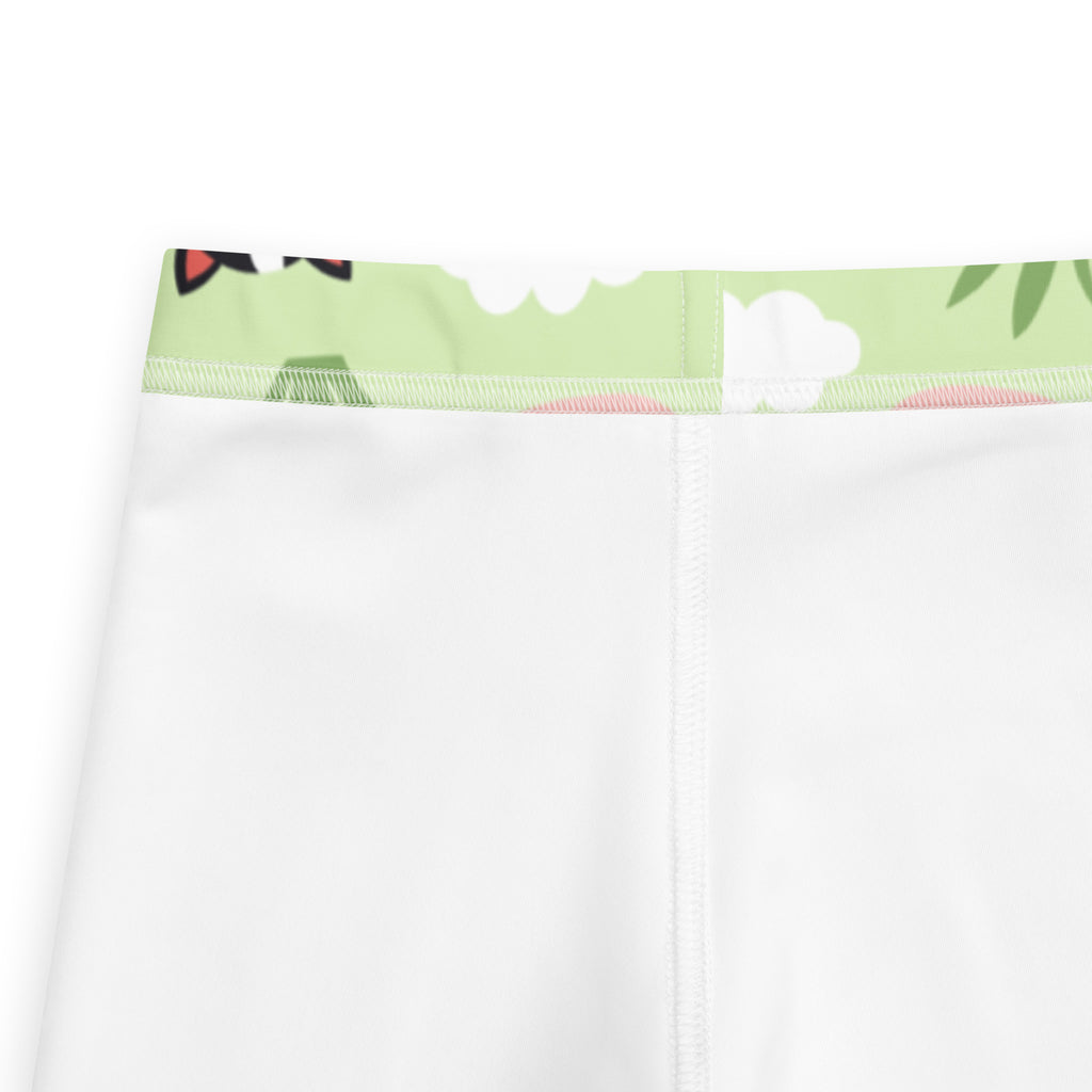 Kids cow print buttery soft leggings in white with a light green waistband featuring clouds leaves and red accents