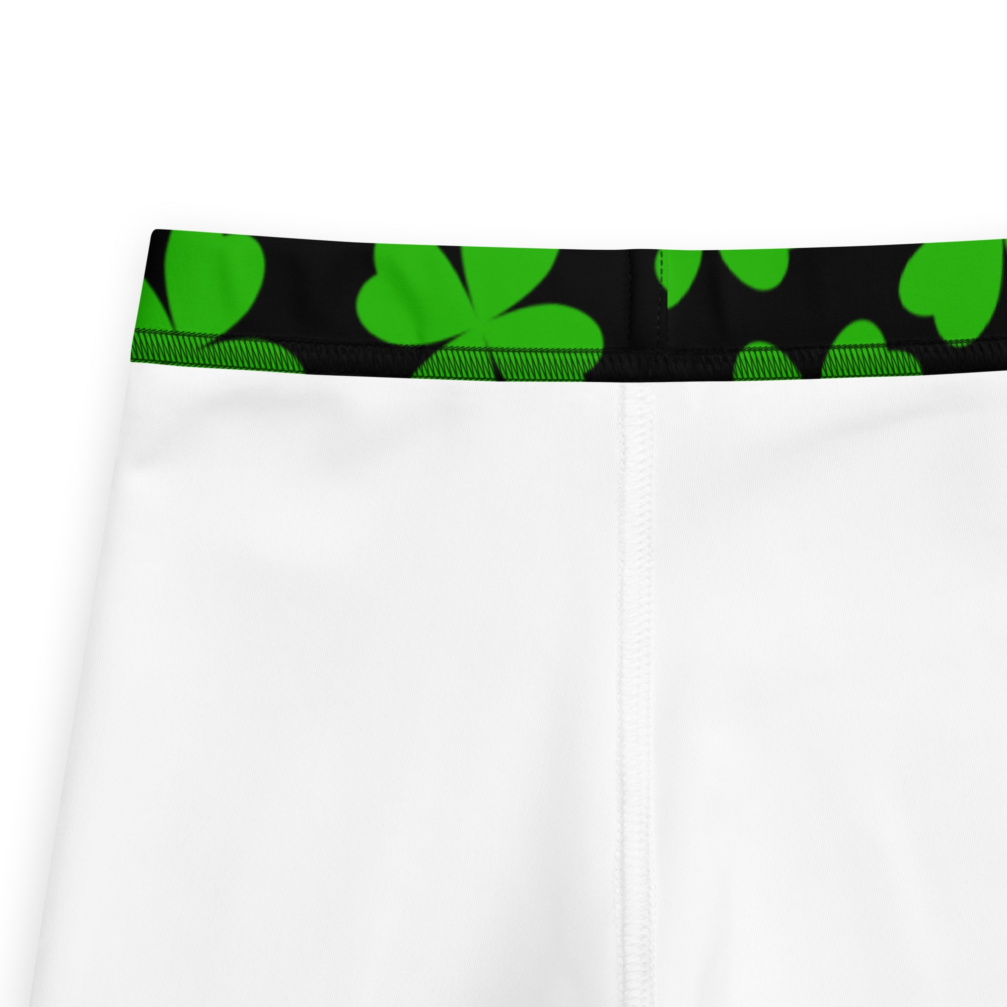 White athletic shorts with a black waistband featuring vibrant green shamrocks in girls black and green shamrock buttery soft leggings
