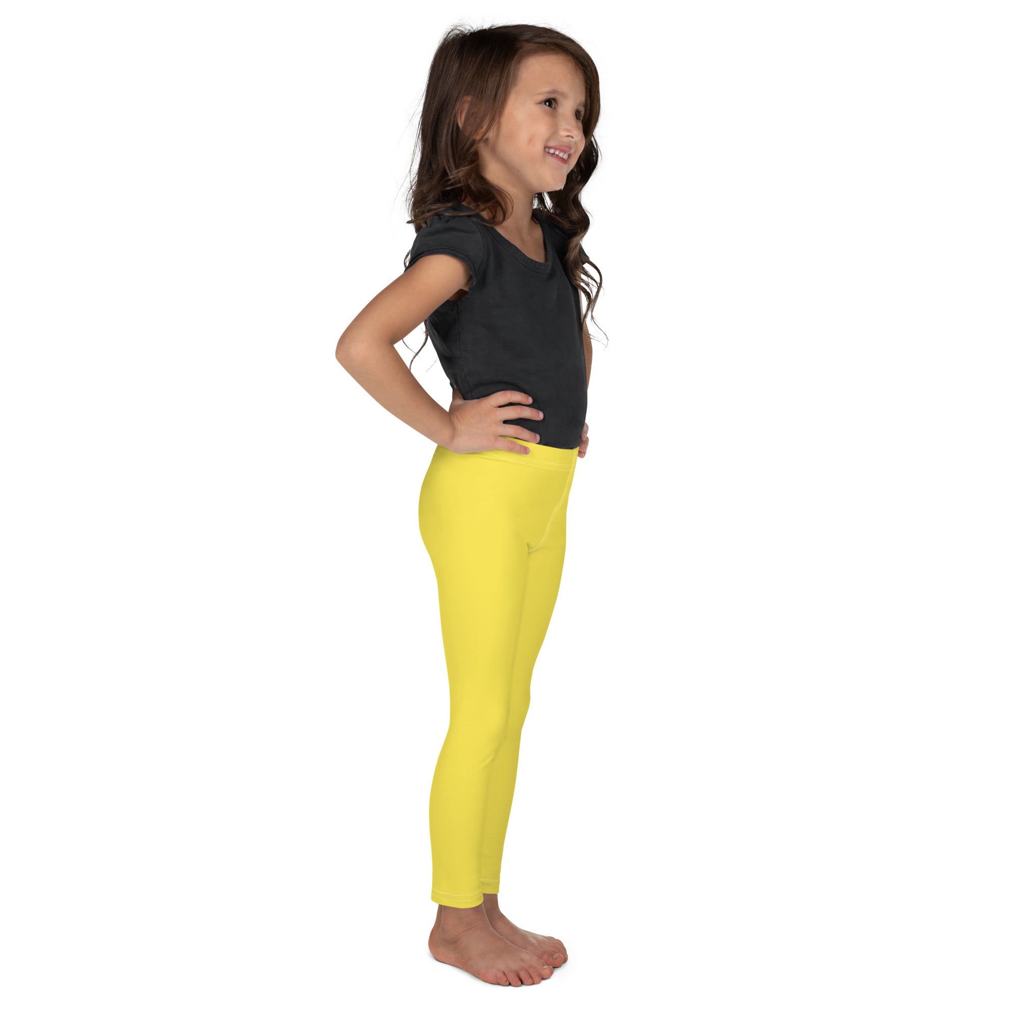 Young girl wearing bright yellow kids buttery soft leggings that are form fitting and comfortable