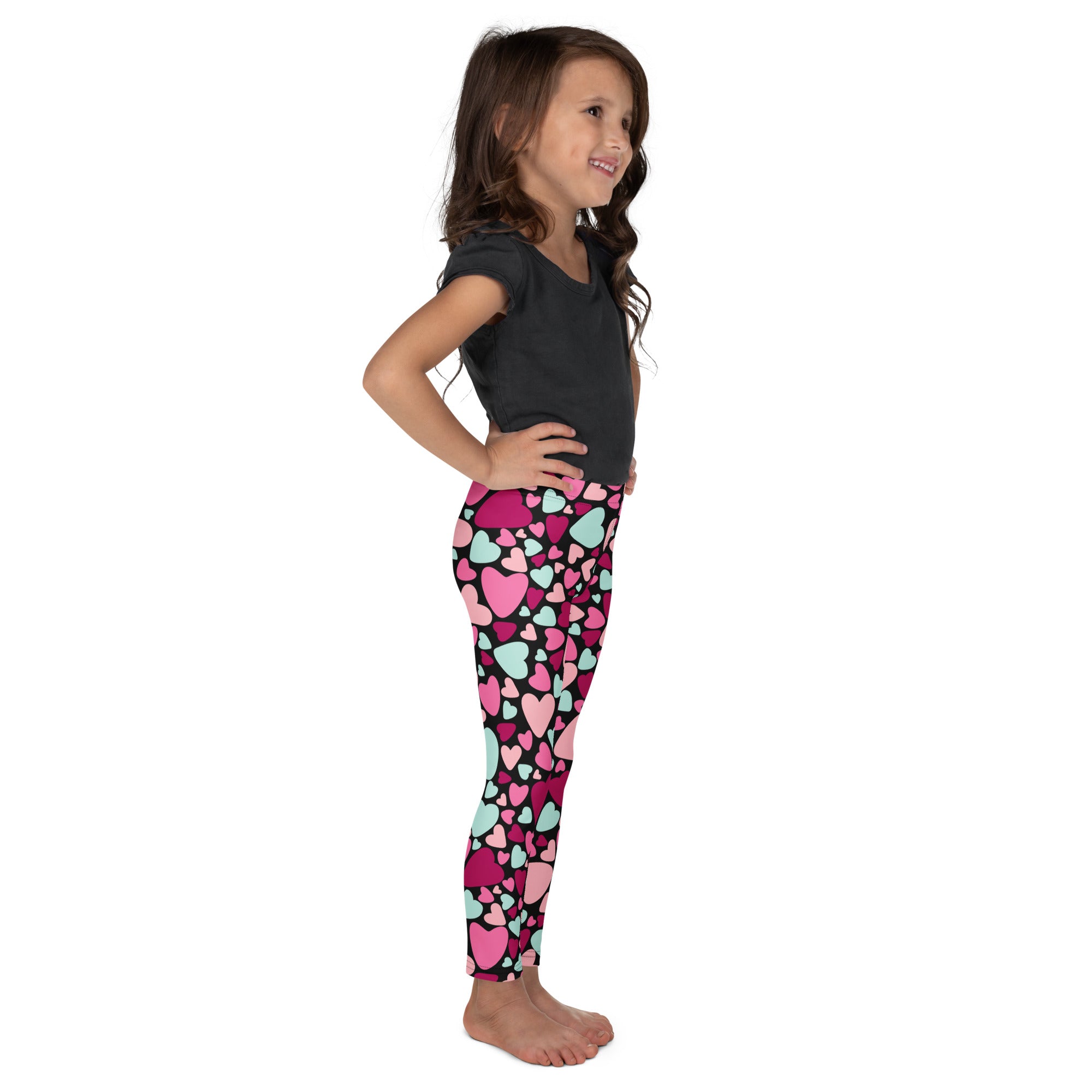 Girls multicolor heart buttery soft leggings with pink and mint heart patterns on a black base