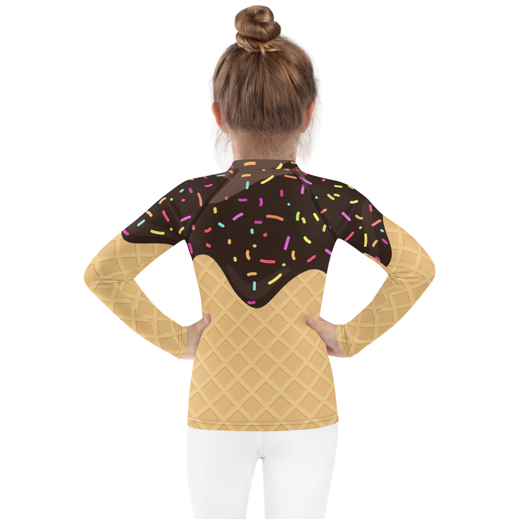 A girl wearing a kids chocolate ice cream waffle cone rash guard with sprinkles long sleeve swim shirt with UPF 50+