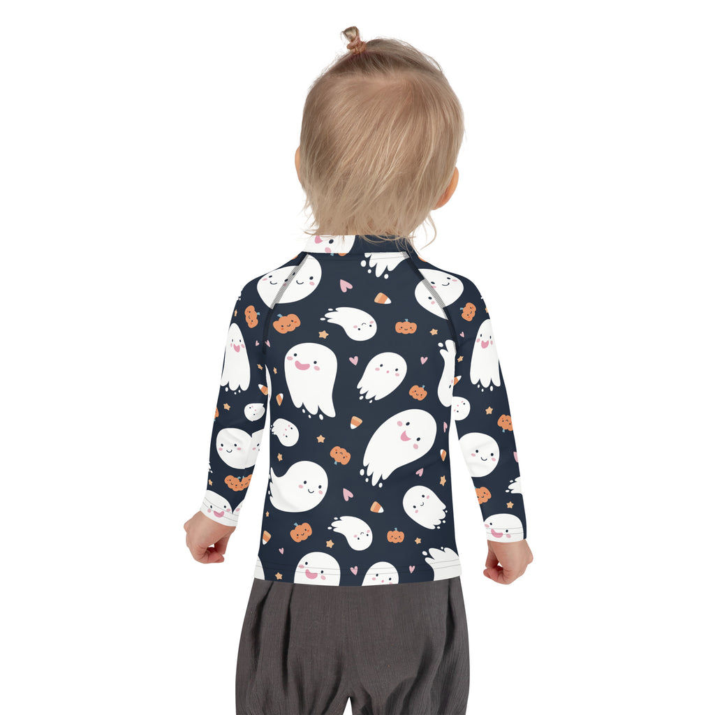 A child wearing a navy blue long-sleeved kids ghost halloween rash guard with white ghosts orange pumpkins and pink hearts