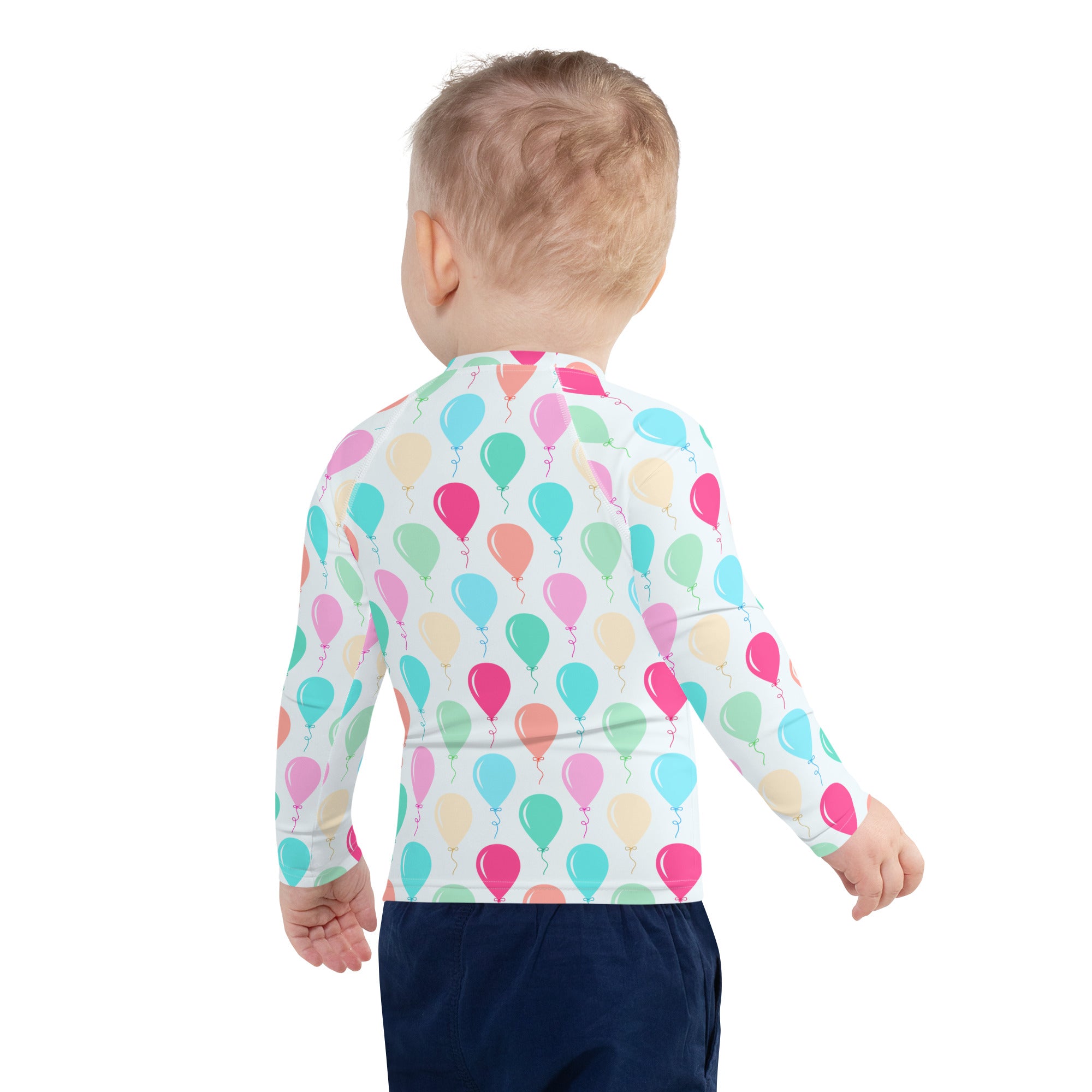 A child wearing a white long sleeve kids birthday balloons rash guard swim shirt with colorful pastel balloons and UPF 50+
