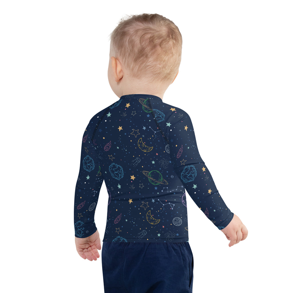 A navy blue kids galaxy long sleeve rash guard swim shirt with space-themed print and upf 50 plus protection