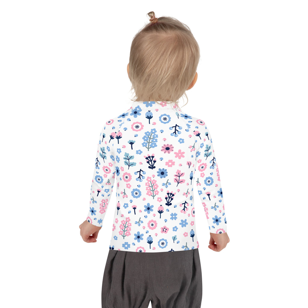 A child wearing a girls pink and blue floral long sleeve rash guard swim shirt with upf 50 plus in white