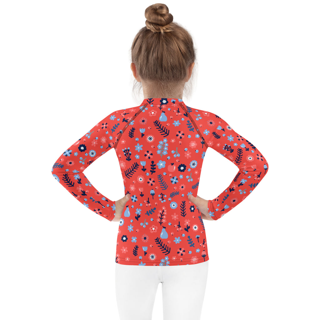 A coral long sleeve rash guard for girls with blue black and white floral patterns and upf 50+ swim shirt protection