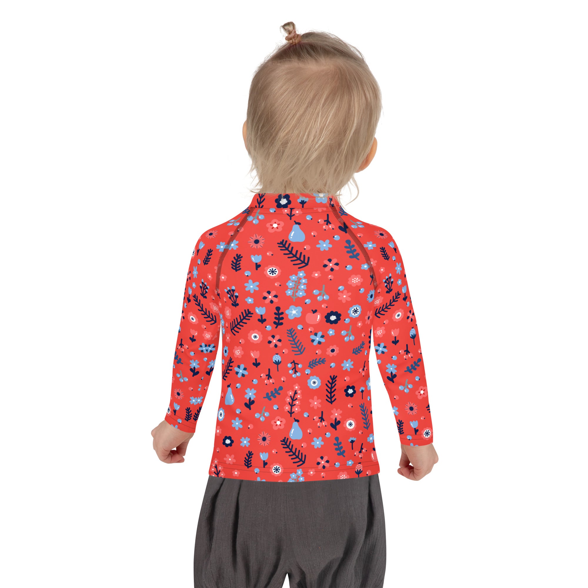 A child wearing a girls red floral long sleeve rash guard swim shirt with UPF 50 plus and playful blue and black patterns