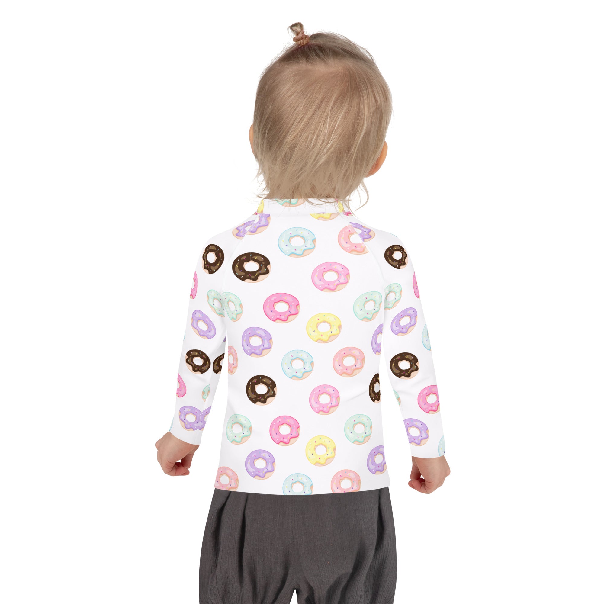 A child wearing a white kids colorful donuts long sleeve rash guard swim shirt with upf 50 plus and pastel prints