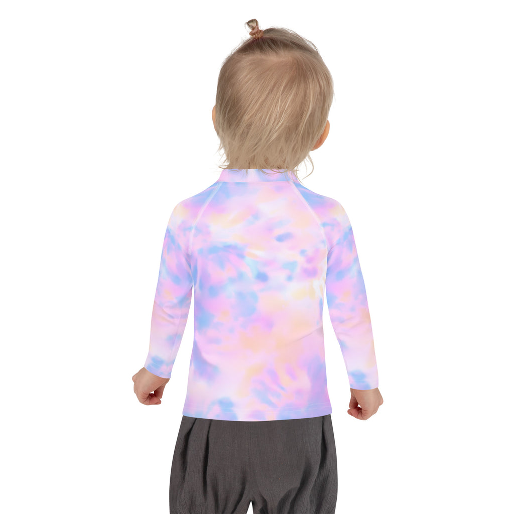 A child wearing a girls pastel watercolor long sleeve rash guard swim shirt with upf 50 plus in pink purple and blue tie dye
